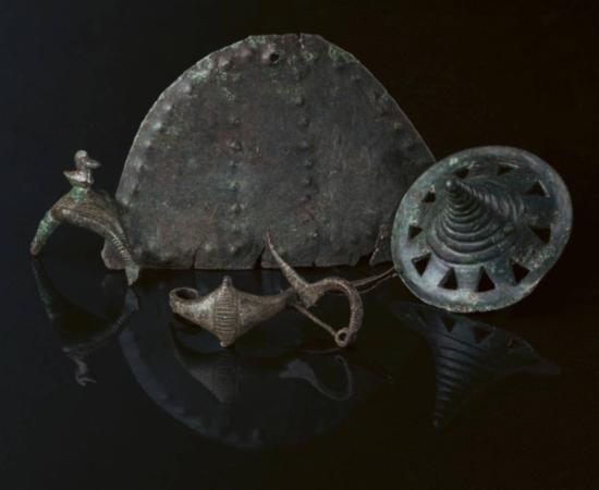 Early Iron Age metal finds from Somló Hill, including a sculpted disc, a brooch, and a large pendant.