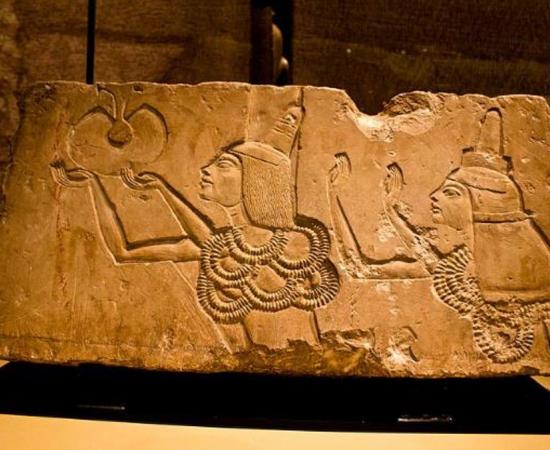 A stone block shows Ay receiving the 'Gold of Honor' award in his Amarna tomb from Akhenaten.