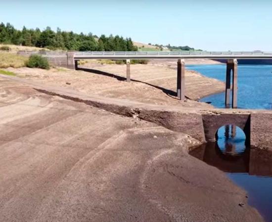 The sunken village of Baitings and its famous packhorse bridge, pictured below the modern car bridge, have been exposed by record drought and heat for the first time since the mid-1950s. Source: YouTube screenshot / velomoho