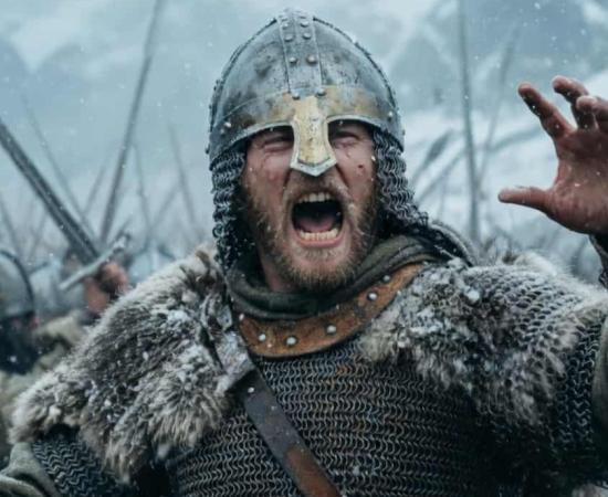 A fierce Viking warrior shouts a war cry mid-battle on a chaotic, snowy field.