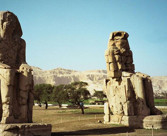 The twin seated Colossi of Memnon, statues of Amenhotep III, on the west back of Luxor, Egypt
