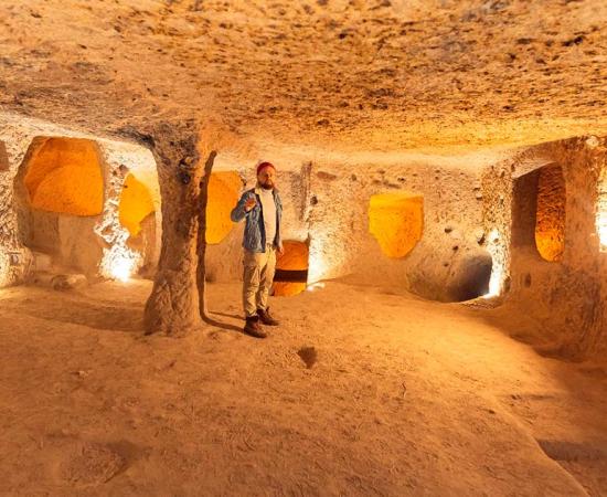 Man standing in underground city of Derinkuyu, Turkey. Source: Parilov / Adobe Stock.