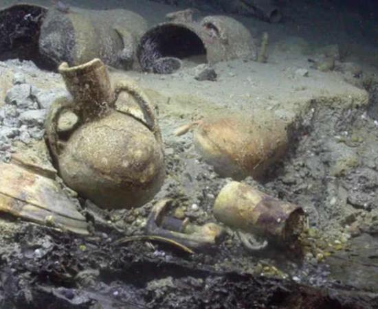 In situ artifacts from Algiers shipwreck, on top of wooden hull elements in the stern of the Barbary Corsair wreck.