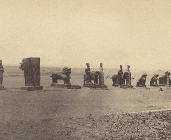 A long line of stone animals and figures standing on open ground along the spirit way of Yongxi Mausoleum, photographed in 1918
