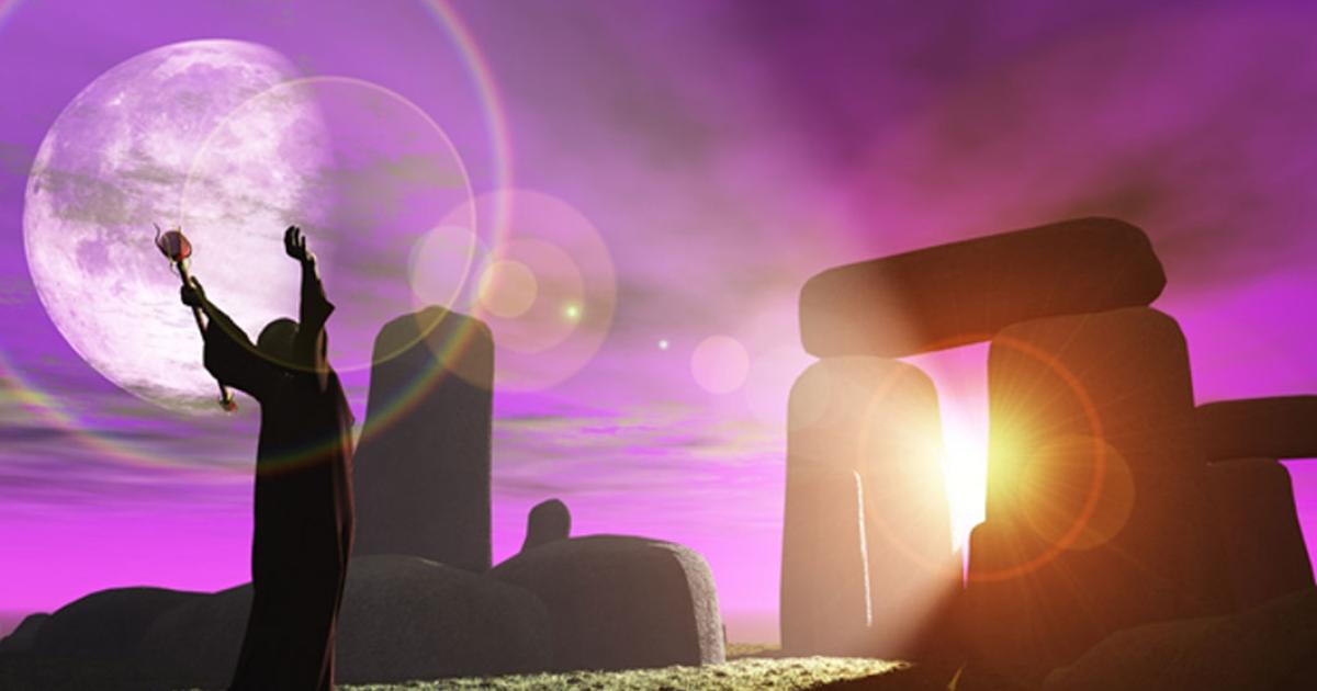 Druid greets the dawn at Stonehenge (heywoody  / adobe stock)