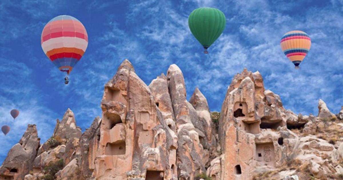 Colorful hot air balloons flying over Red valley in Cappadocia, Anatolia, Turkey (Svetlana Nikolaeva/ Adobe Stock)