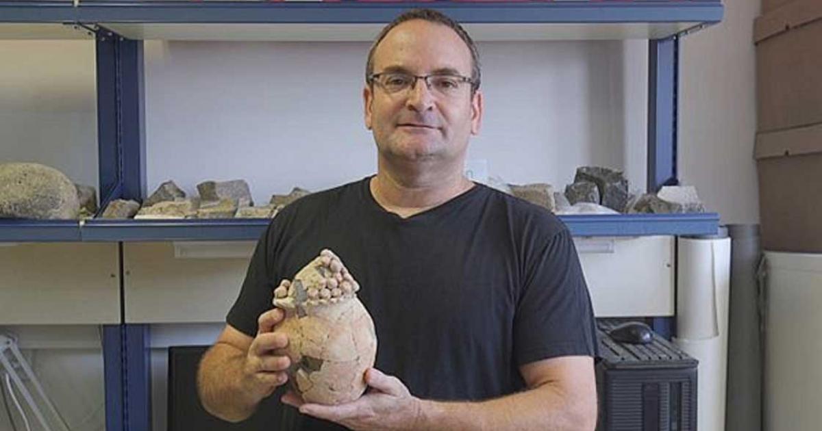 Haifa University Prof. Danny Rosenberg holds the 7,200-year-old model clay grain silo found at Tel Tsaf in the Jordan Valley.