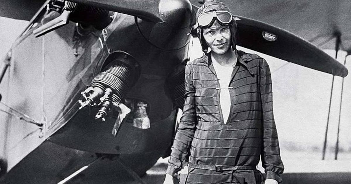 Amelia Earhart standing outside of her airplane after landing it. 