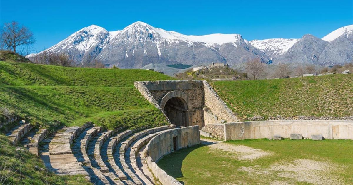 Alba Fucens, Roman archaeological site with amphitheater. Monte Velino mountain with snow, Abruzzo region, central Italy   Source: ValerioMei / Adobe Stock