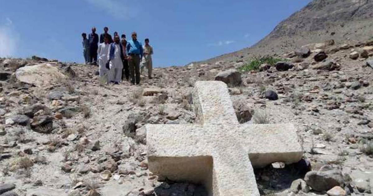 A group of locals posing with the ancient cross in Pakistan.    Source: Pamir Times