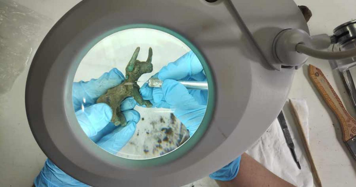 Conservators clean up the bronze bull idol uncovered in Olympia.	Source: Greek Ministry of Culture and Sports