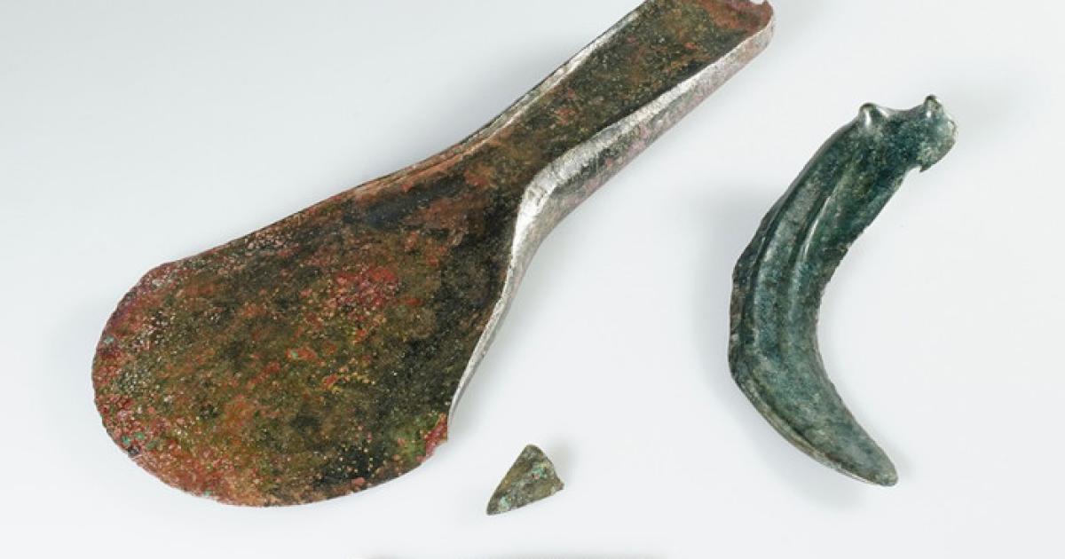 : A collection of Bronze Age objects found at the site, including the axe, dress pin, and sickle