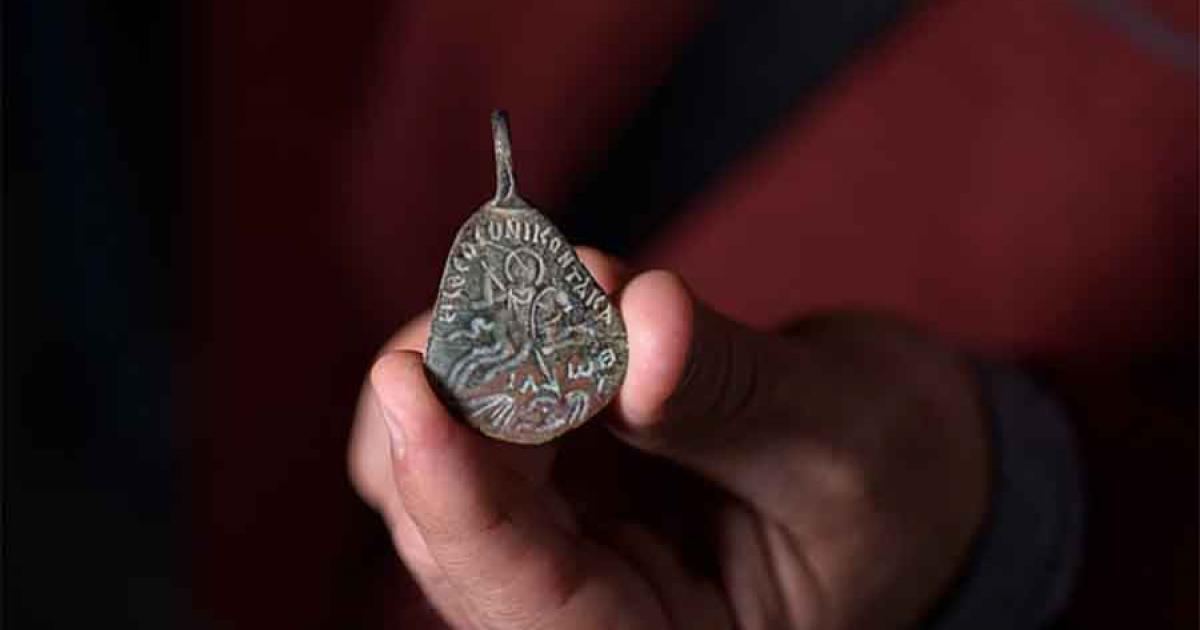 Dr. Eitan Klein, Archeologist and Deputy Director of the Antiquities Theft Prevention Unit for Israel Antiquities Authority, holding the Byzantine-amulet under investigation. 