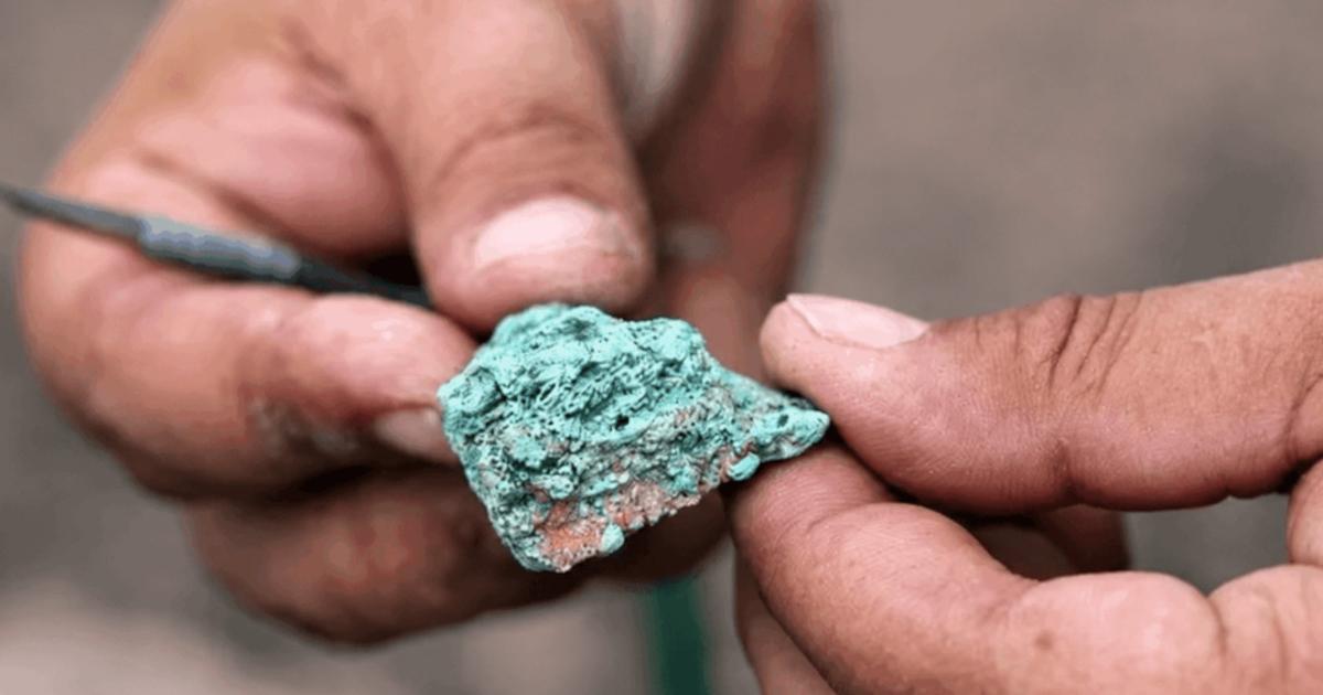 An excavator examines a malachite fragment from the 9,000-year-old Çayönü copper workshop.