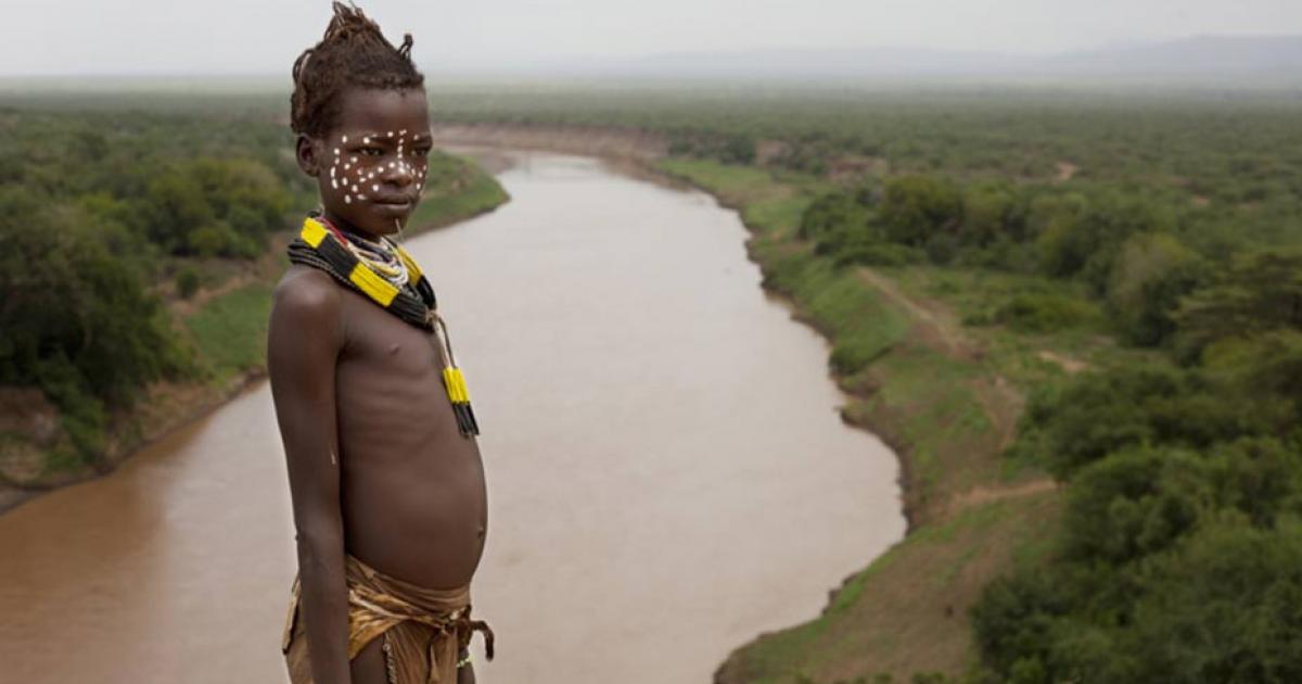 Child from the Karo tribe with the Valley of the Omo River behind.