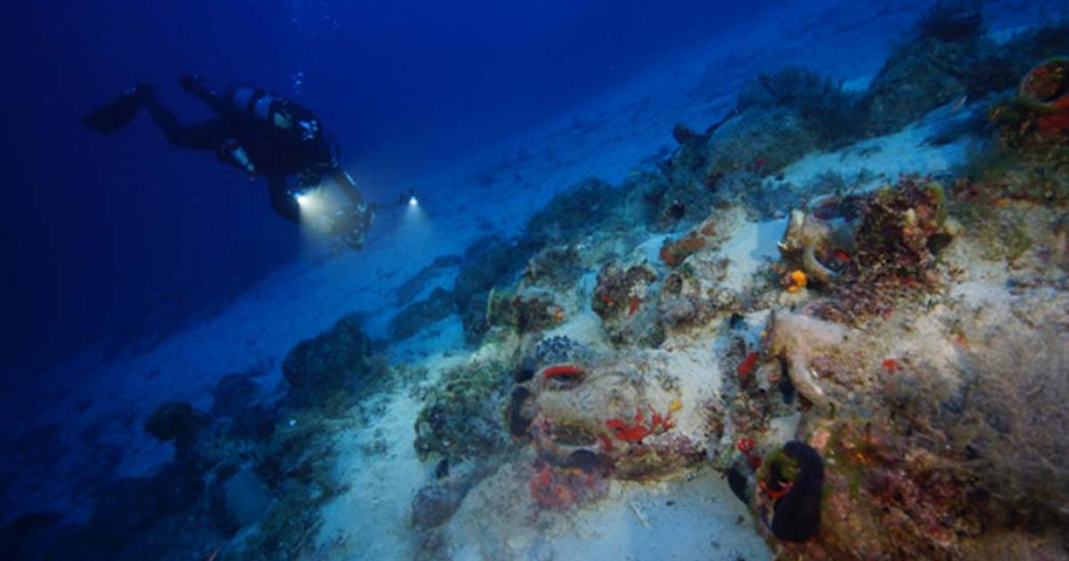 An archaeologist systematic photographs a wreck site to create a 3D site plan by Vasilis Mentogiani.
