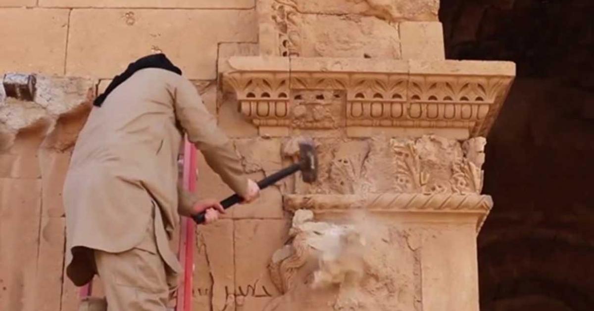 An Islamic State militant destroying artifacts in Iraq’s World Heritage city of Hatra 