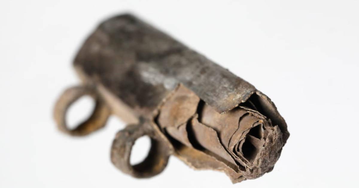 Close-up photograph of rolled up silver foil scroll inside silver amulet from third century BC, found in Frankfurt, Germany.