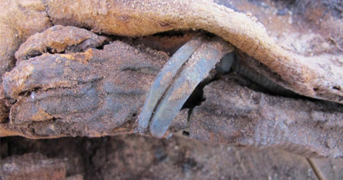 The arm and hand of a young infant wearing a bracelet found at Fag el-Gamous