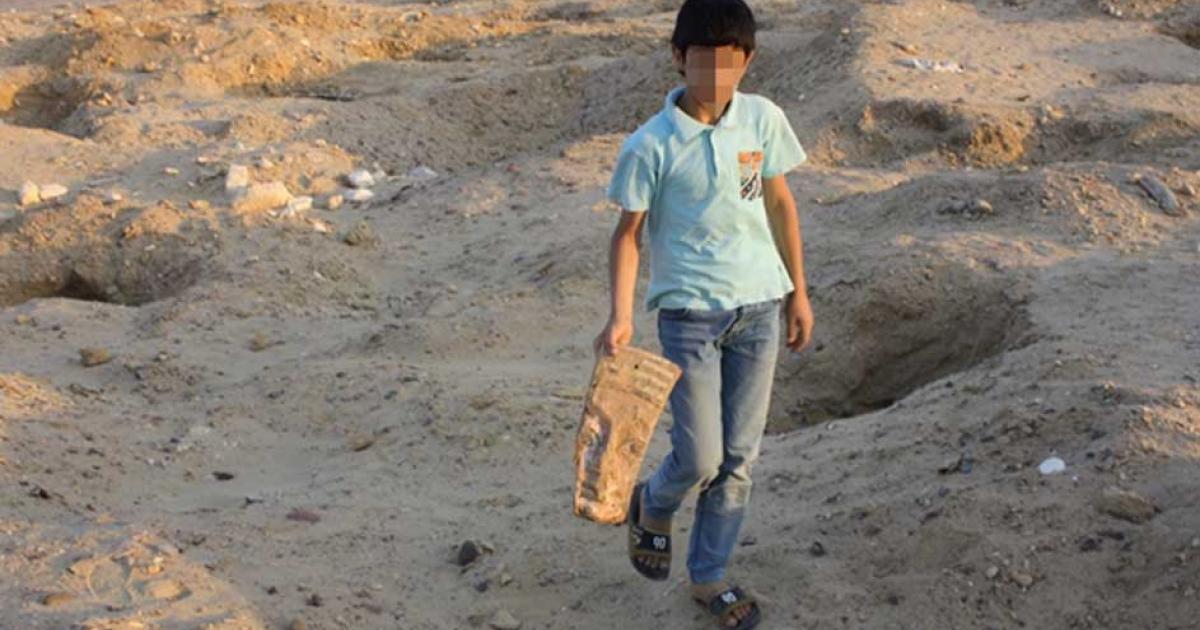 A child carrying an artifact at the cemetery. 