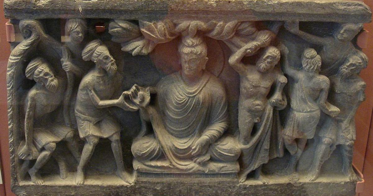 A Kushan empire (30–375 AD) frieze showing the Buddha flanked on the left by a Greek-inspired Vajrapani that clearly highlights the aesthetic nuances of Greek Buddhism.		Source: Goldsmelter / CC BY-SA 4.0