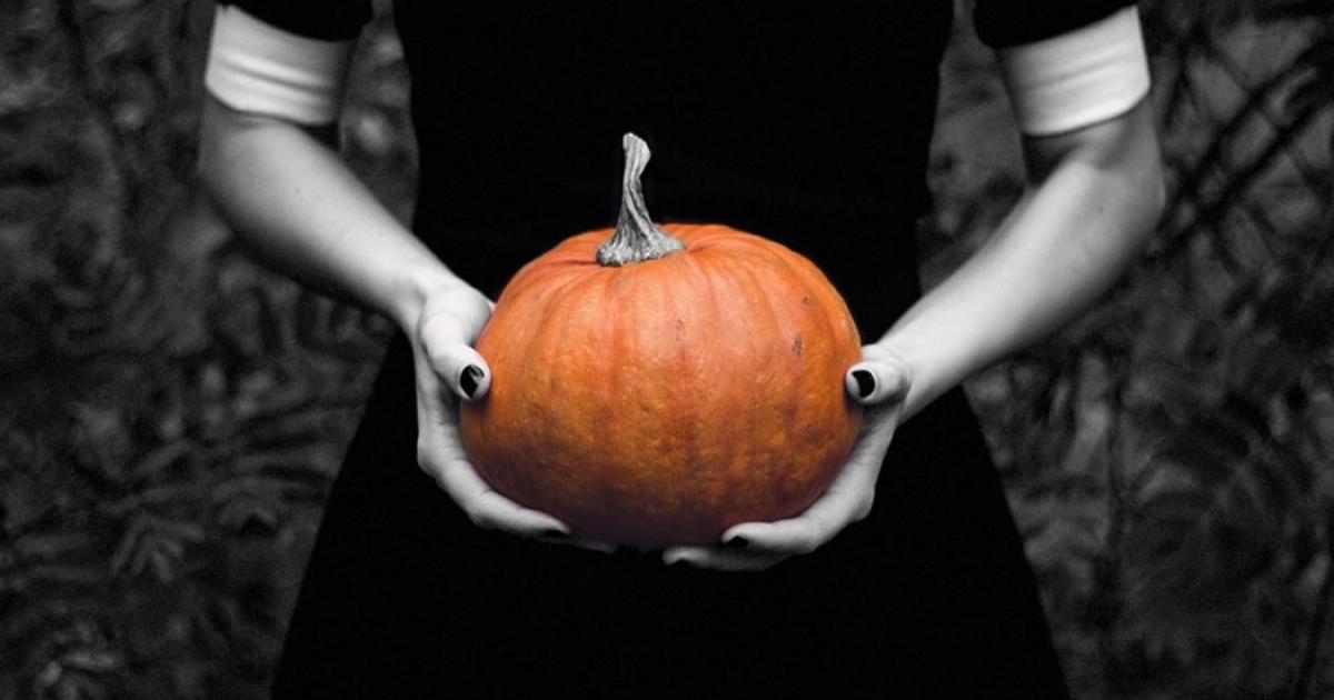 A ghostly pale woman holding a pumpkin. Halloween and paranormal phenomena often go hand in hand.