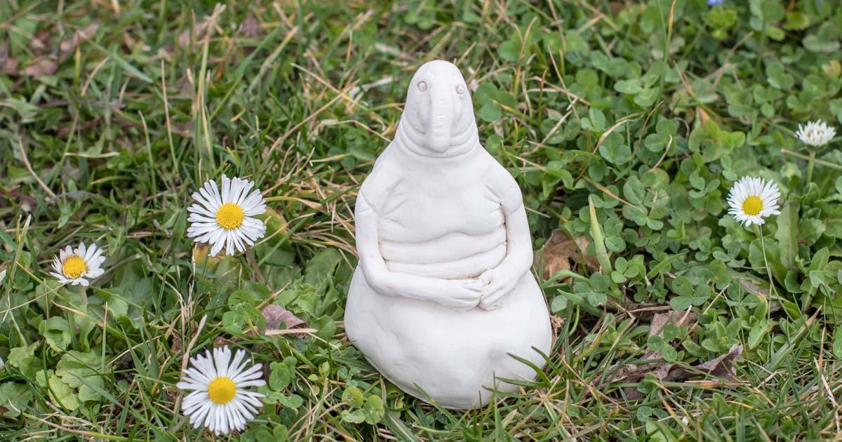 Clay homunculus model placed on a lawn