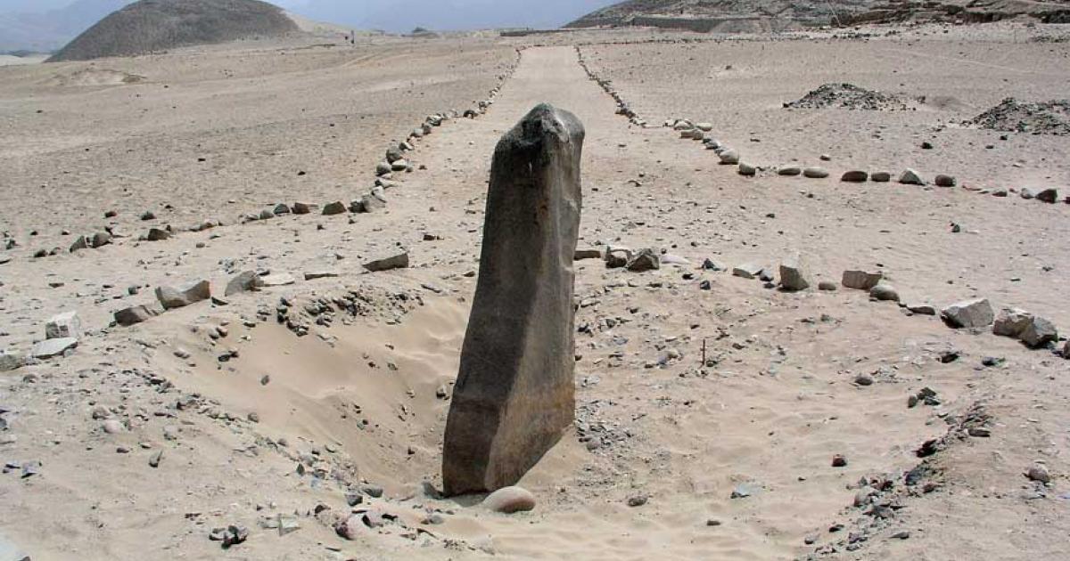 The monolith called Huanca with pyramids in the background in Caral-Supe