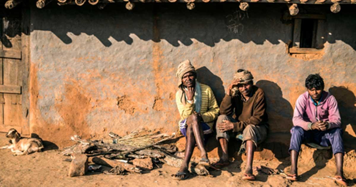 A group of Asur men outside a traditional hut in Polpol Path.