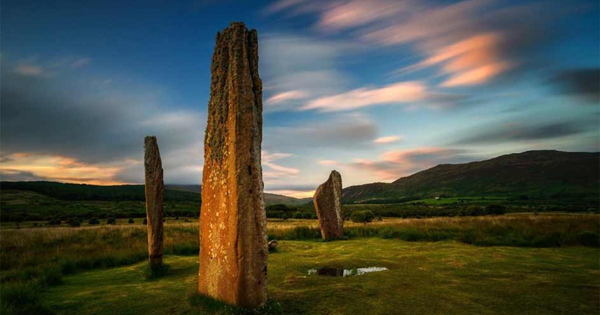 Machrie Moor on the Isle of Arran at sunset with two magnificent standing stones in the foreground. Source: swen_stroop / Adobe Stock
