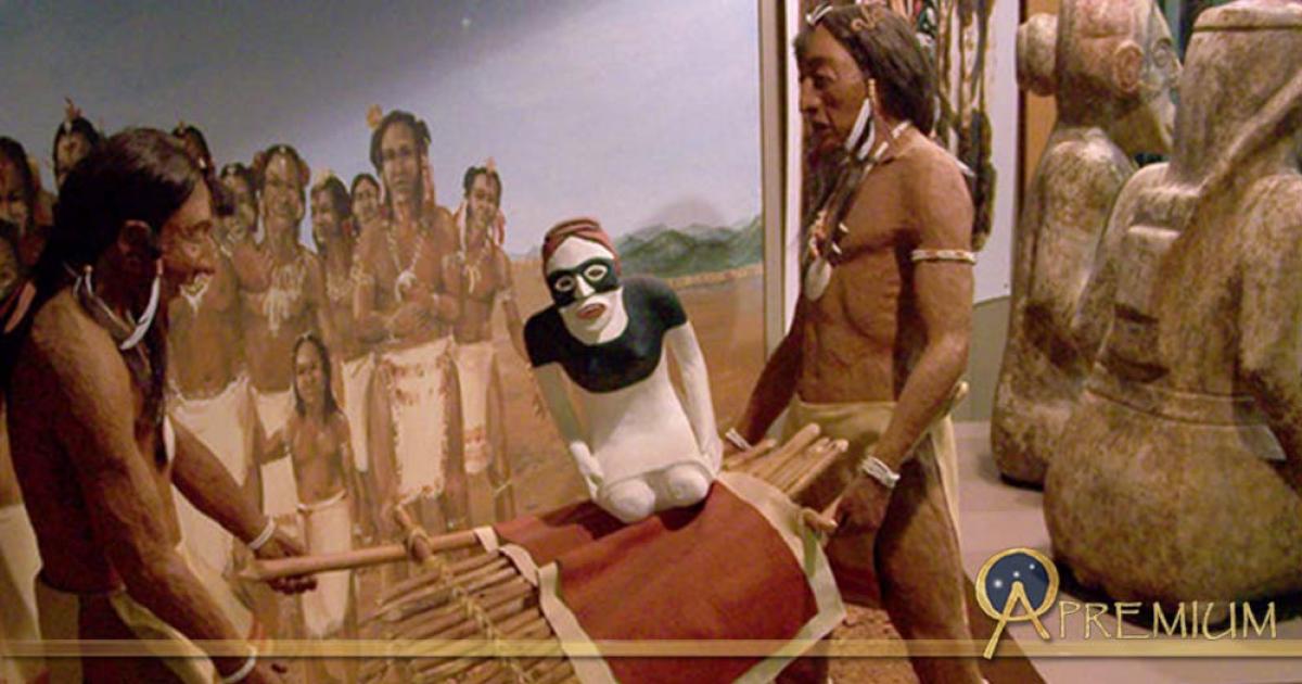 A diorama at the Etowah Mounds showing two stone effigies being ritually buried, next to the actual statues, seen from the rear