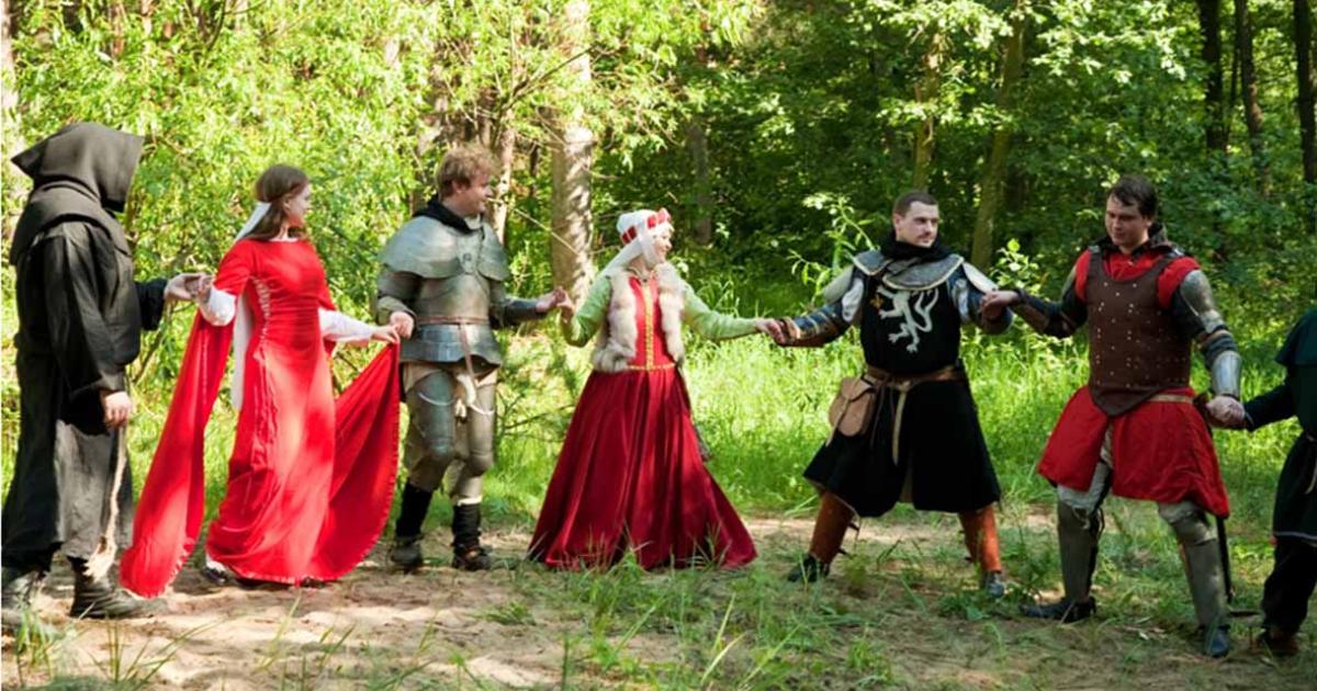 A group in traditional medieval attire engaged in a medieval circle dance.   Source: JackF /Adobe Stock                