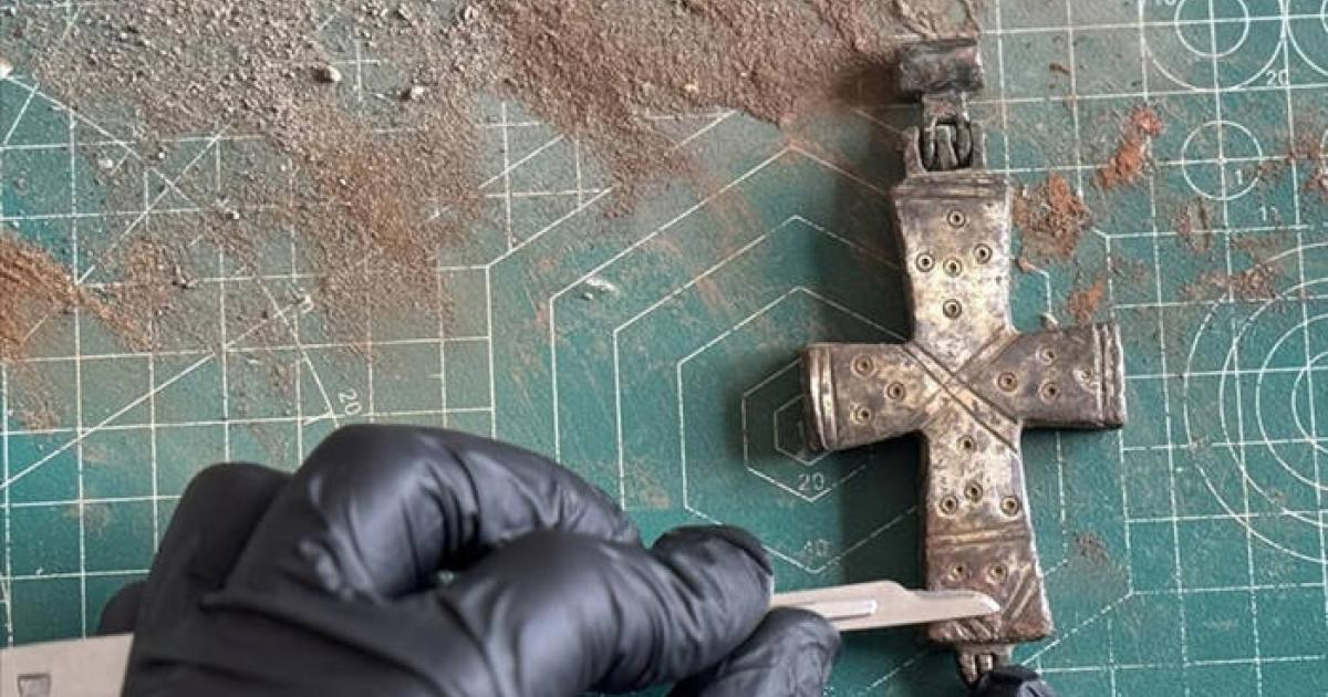 A conservator applies delicate conservation work to the intact, permanently sealed bronze reliquary cross found at Lystra.