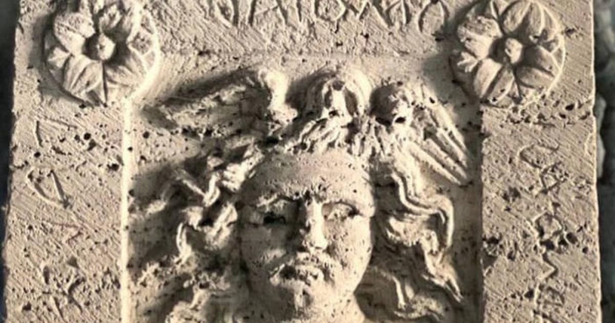 Burial urn with Medusa relief and Etruscan inscription.
