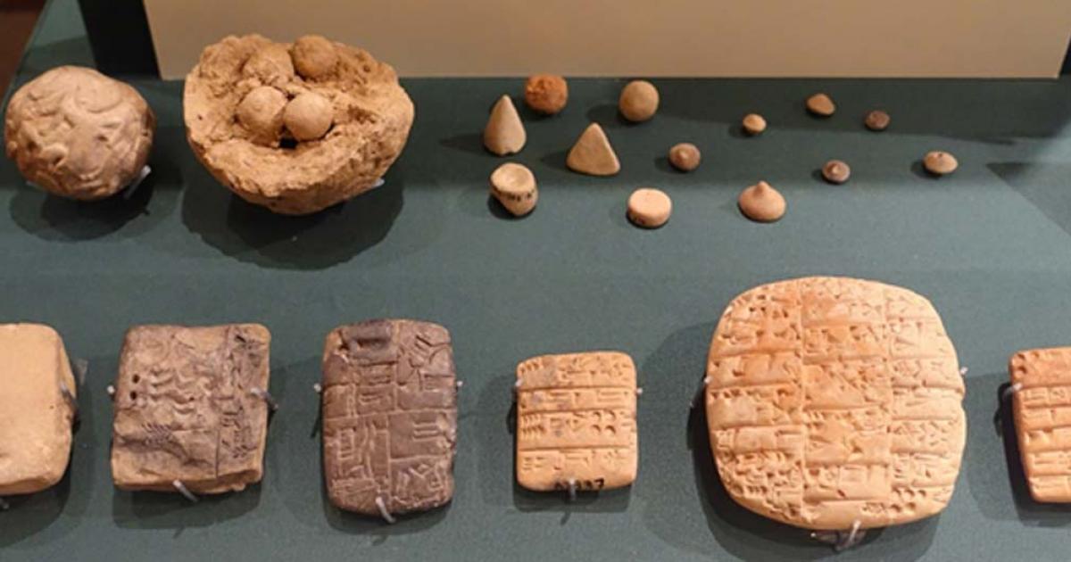 Clay accounting ball with calculi, counters, and evolution of cuneiform. Exhibit in the Oriental Institute Museum, University of Chicago, Chicago, Illinois, USA 