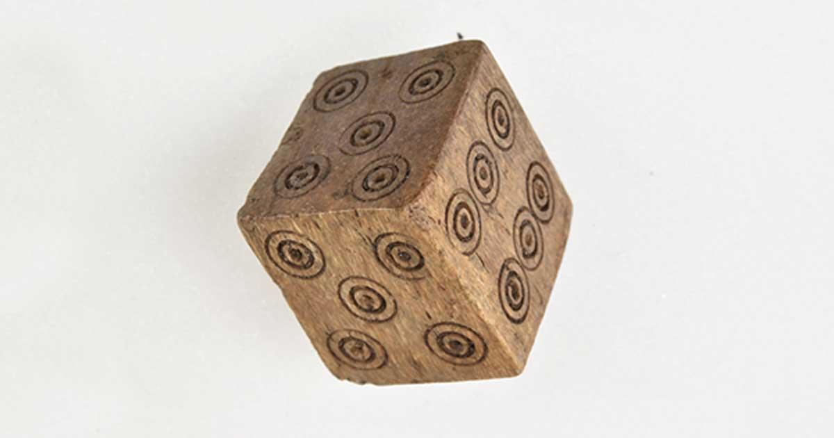 This Medieval dice has two 4's and two 5's but no 1 or 2. Archaeologists believe that it was likely used to cheat while gambling. This photo shows the two 5's. 