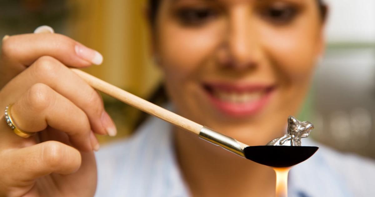 Woman practicing molybdomancy for New Year’s Eve. (Source: Gina Sanders / Adobe Stock