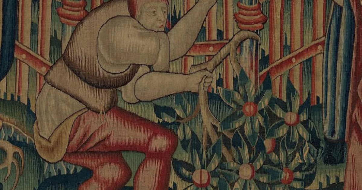 A medieval woodcutter chops down branches for firewood. 