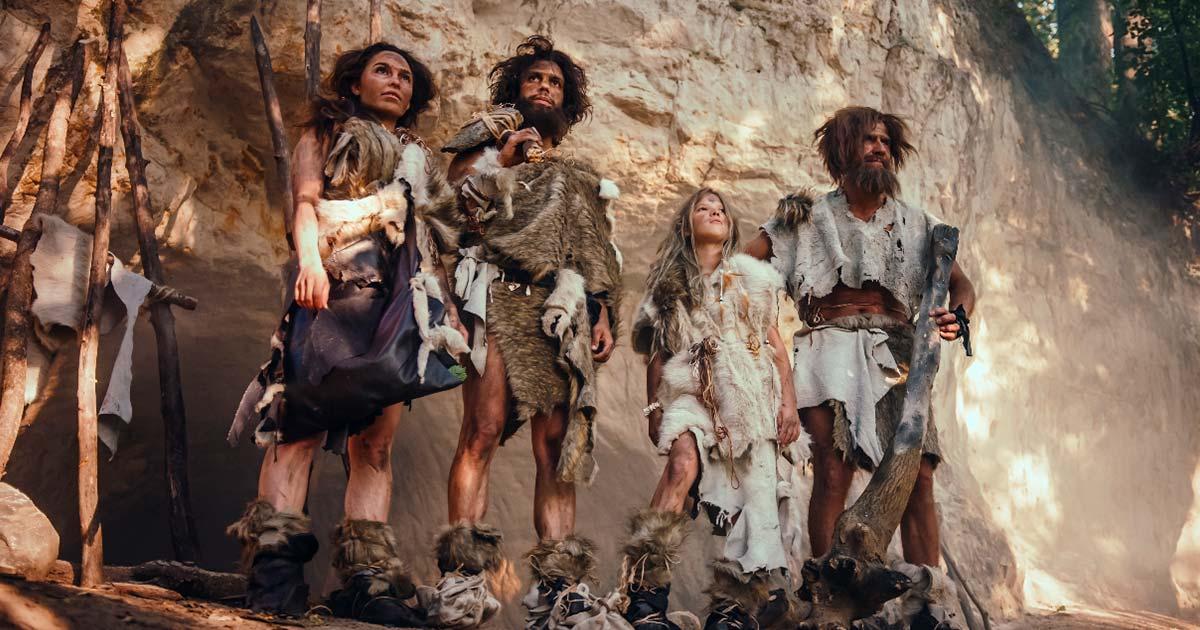 Tribe of four ancient humans wearing animal skin.  Source: Gorodenkoff/Adobe Stock