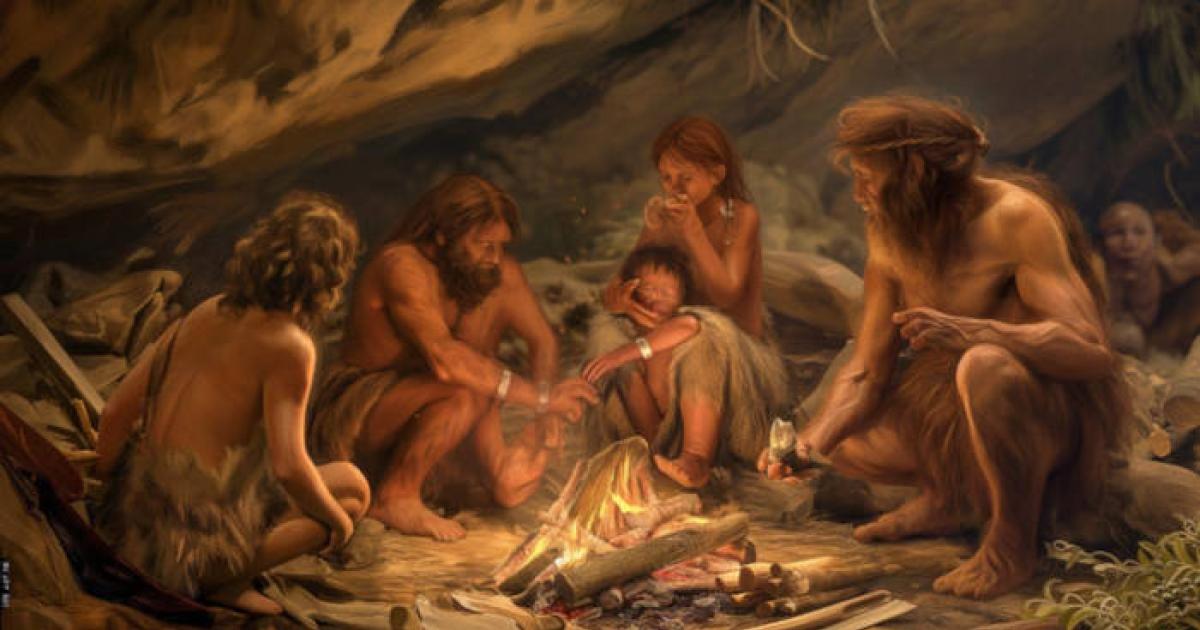 Representation of Neanderthals in a cave around a fire.