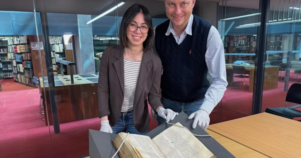 : Dr Elisabetta Magnanti and Dr Mark Faulkner with the Trinity copy of Bede’s Ecclesiastical History