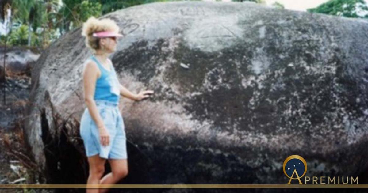 Phallic megalith covered with glyphs and author in the Pohnpaid meadow (Image © 1992 Carole Nervig)