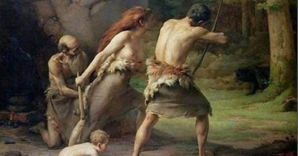 Prehistoric man and woman carrying weapons.