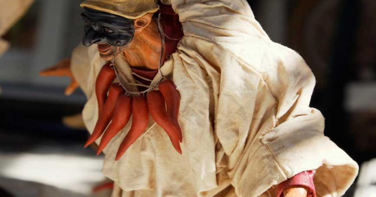 A figurine of Pulcinella with his mask