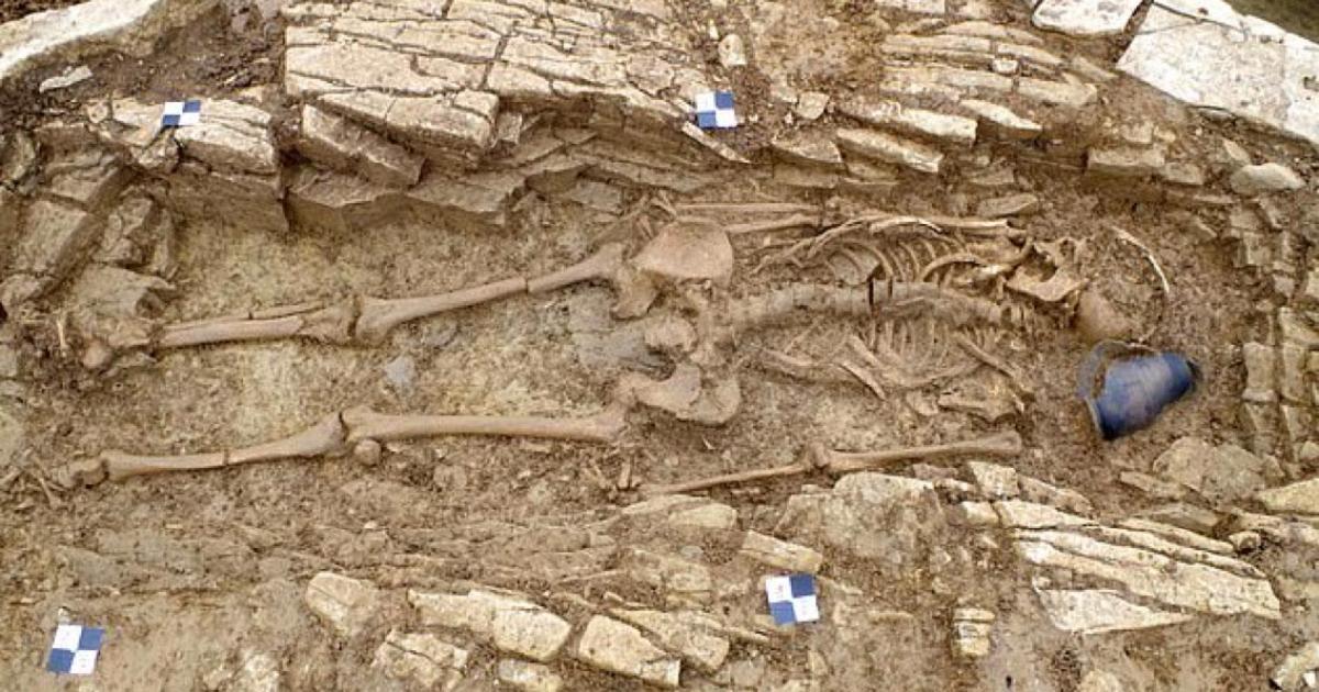 One of the Roman slave skeletons alongside a pot found at the burial site in Somerset, England. Source: Wessex Archaeology