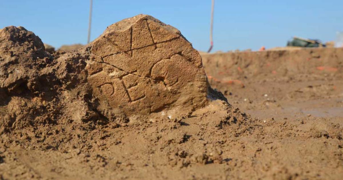 An inscribed section of an altar stone in situ at one of the two Roman temples discovered in Herwin-Hemeling in the Netherlands near the German border. Source: ©RAAP
