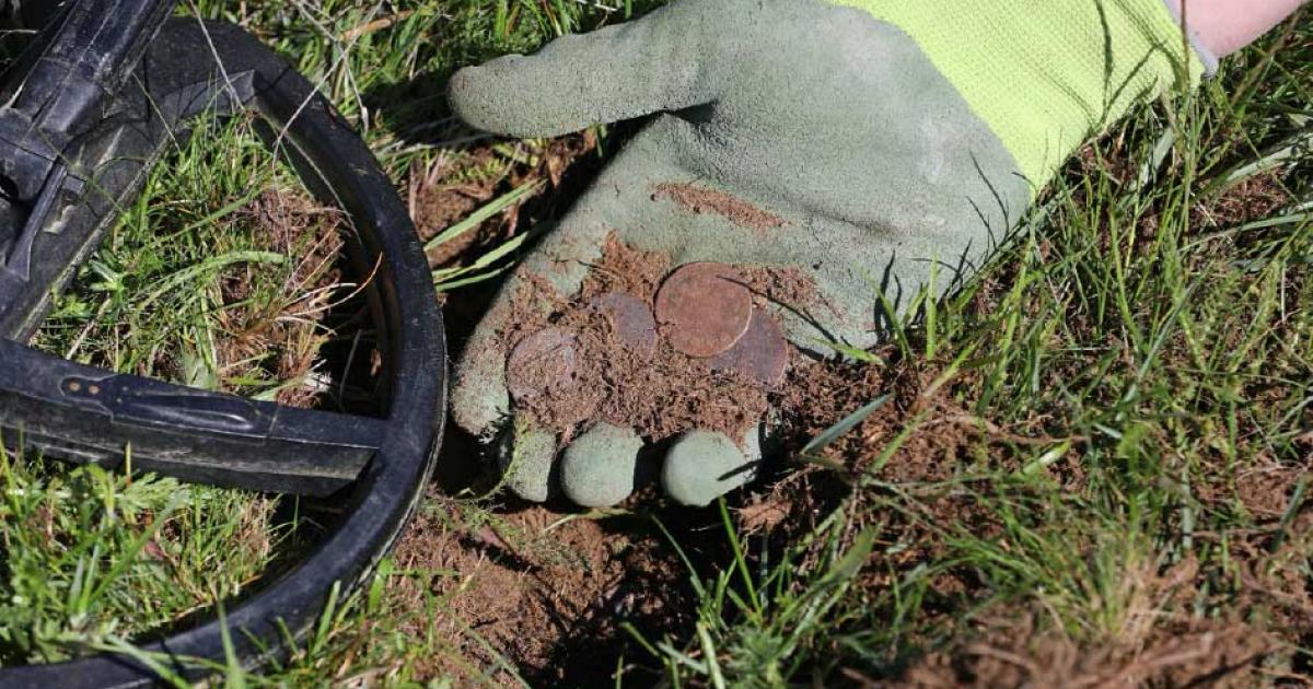 A metal detectorist finds coins (representational image). Credit: sablin / Adobe Stock
