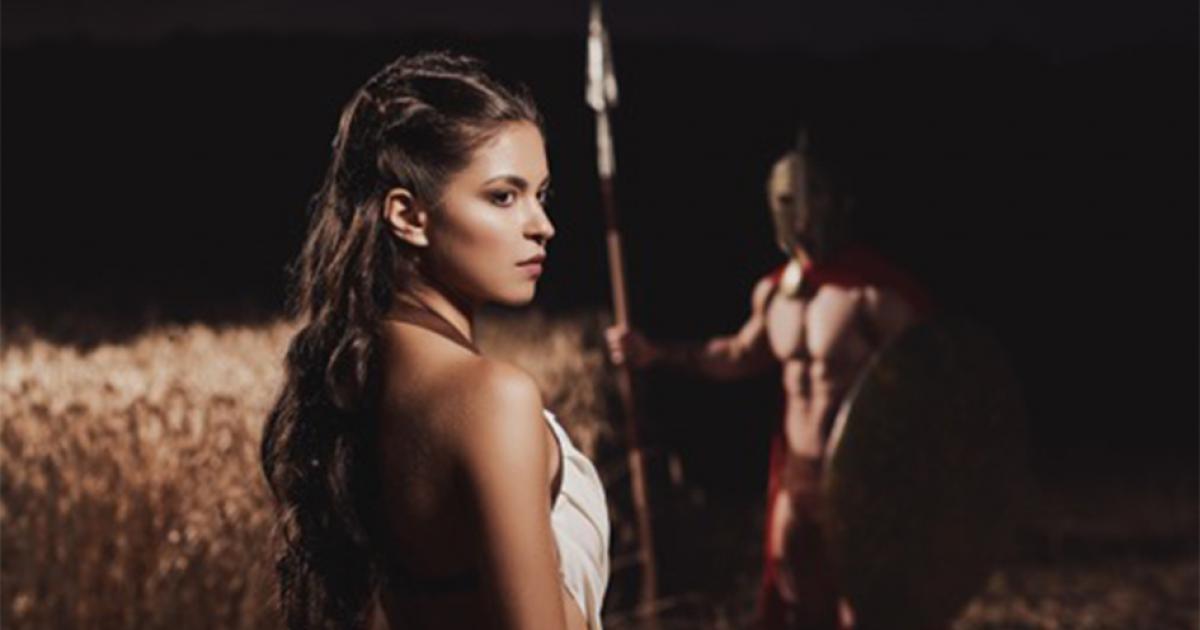 Spartan woman in foreground with her warrior husband in the background.   Source: serhiibobyk / Adobe stock