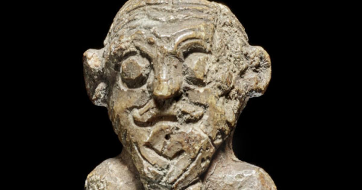 The small walrus ivory figurine discovered in Denmark's National Museum, showing intricate Viking hairstyling 