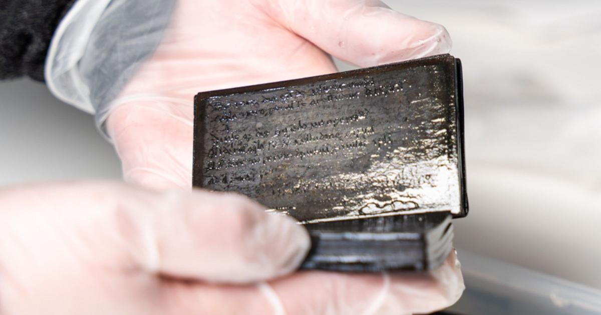Researcher holding the 13th-14th century medieval wax notebook.